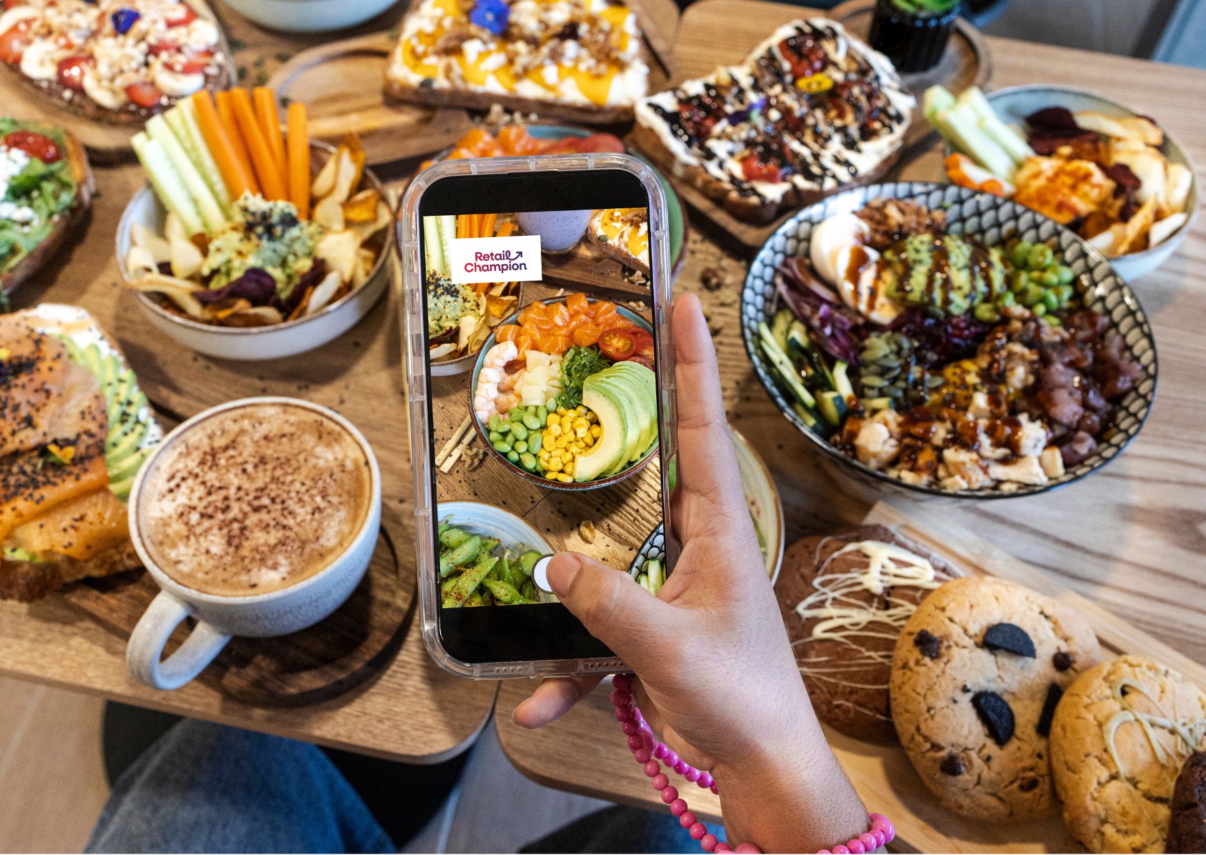 Table of food with a hand and mobile taking a photo