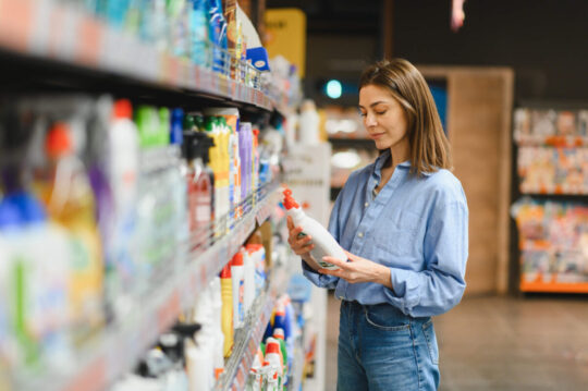 A shopper comparing products while making a purchase decision in a retail store.