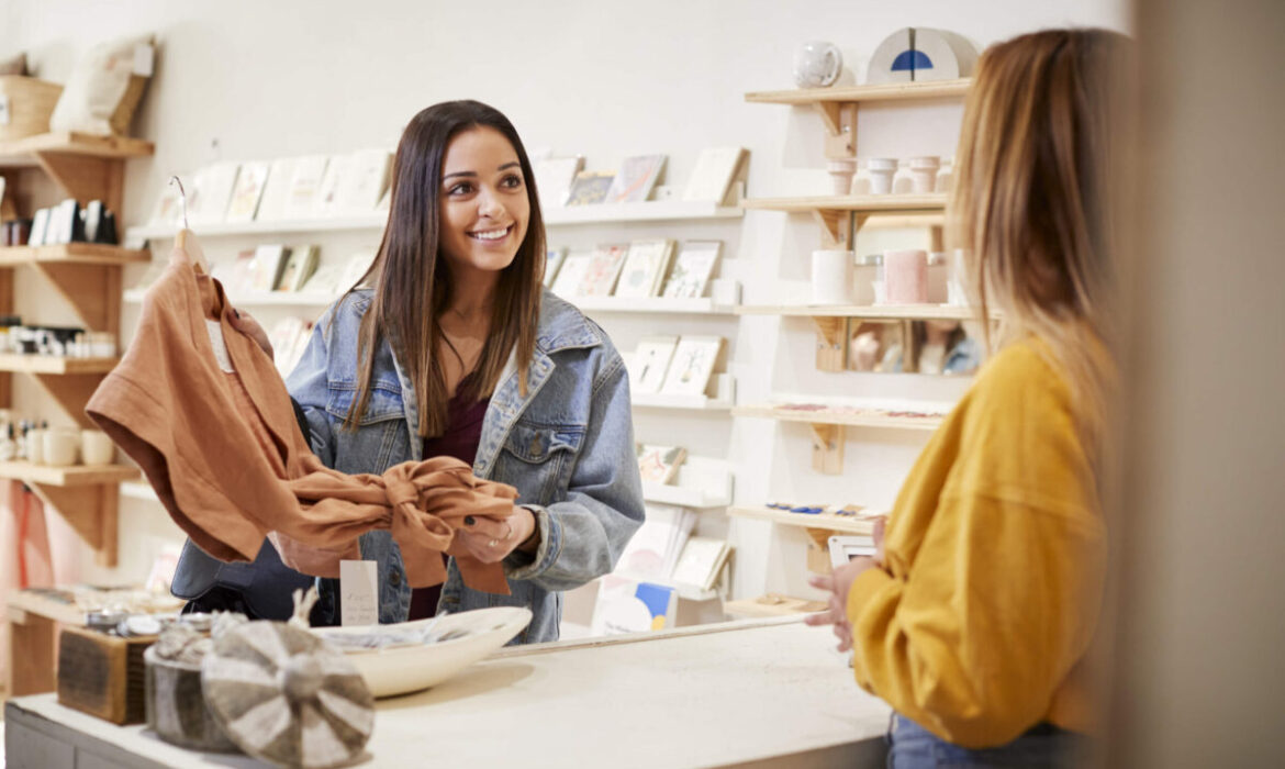 A retail associate helping a customer choose a product in store.