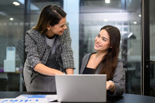 Colleagues reviewing a shared business report before making a decision.